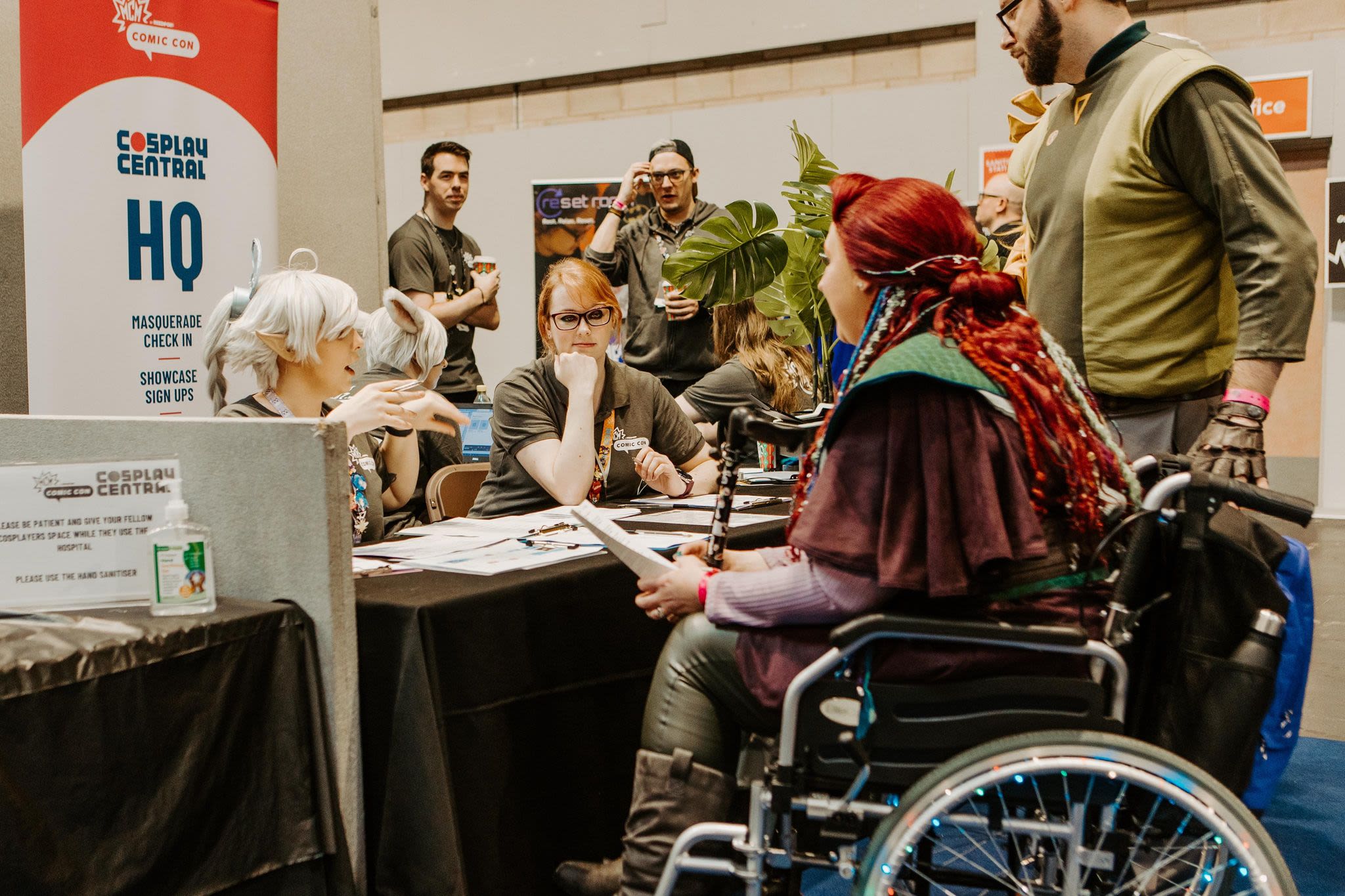 A woman in a wheelchair checking into cosplay central HQ