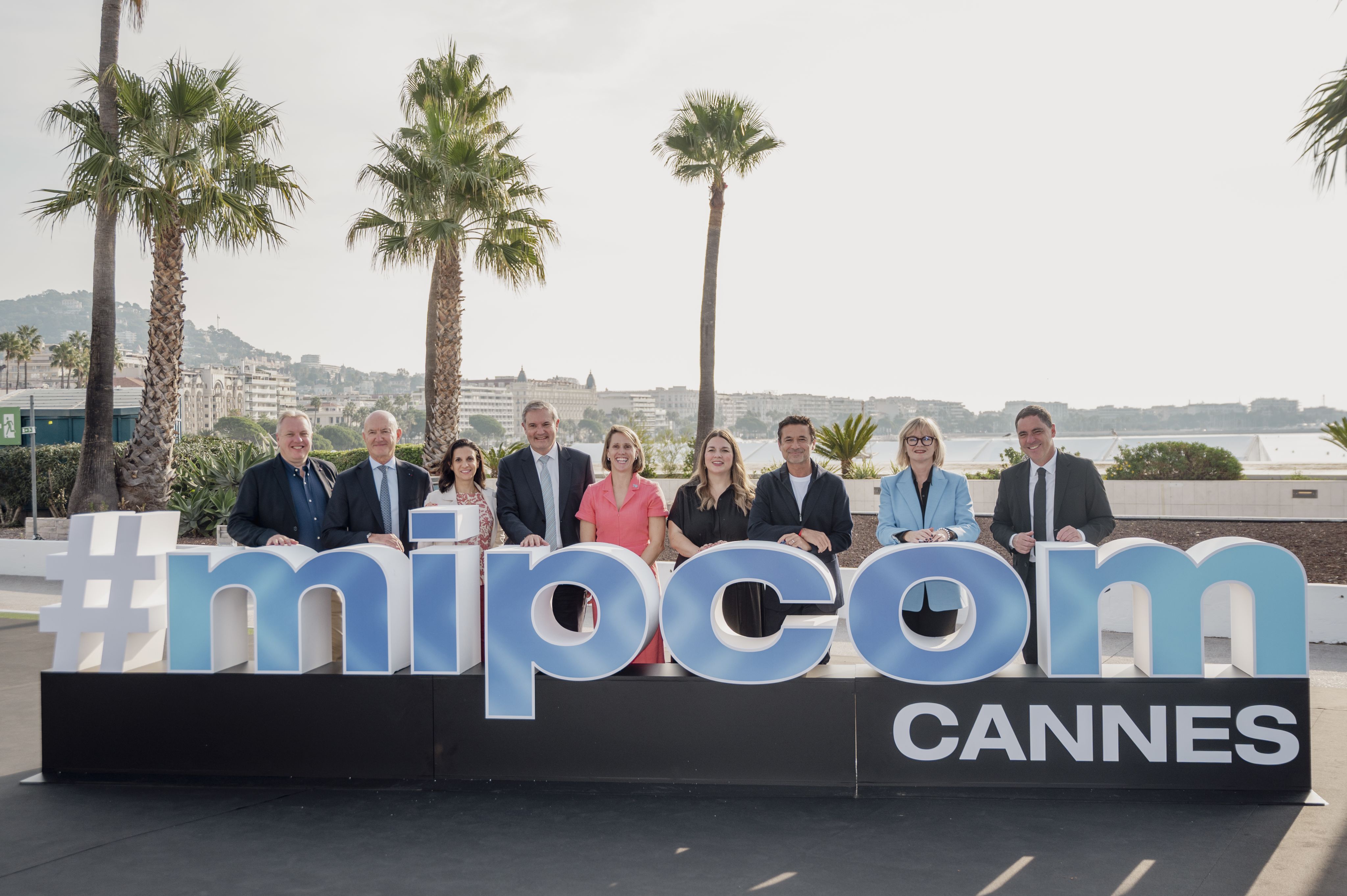 Team posed behind a #mipcom Cannes sign