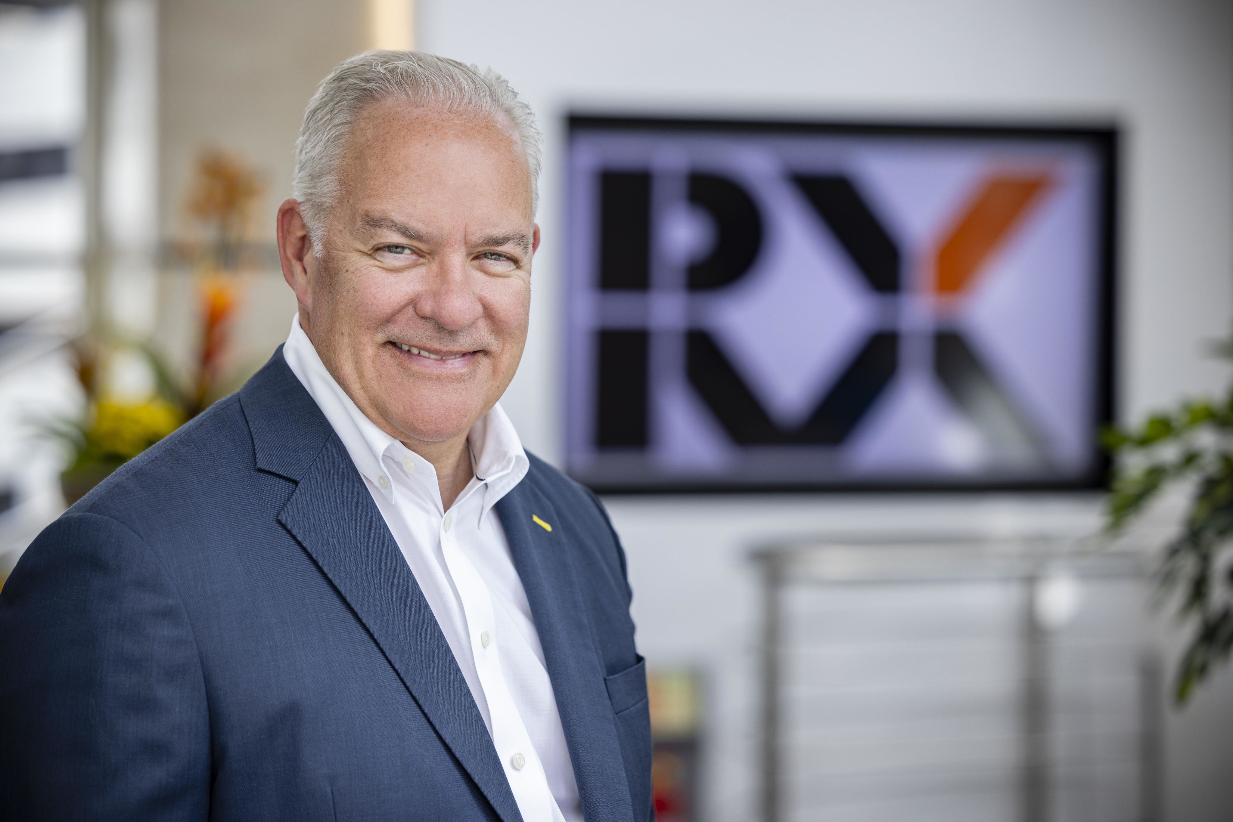 Luiz Bellini and a guest speaker taking a selfie on stage with the audience in the background