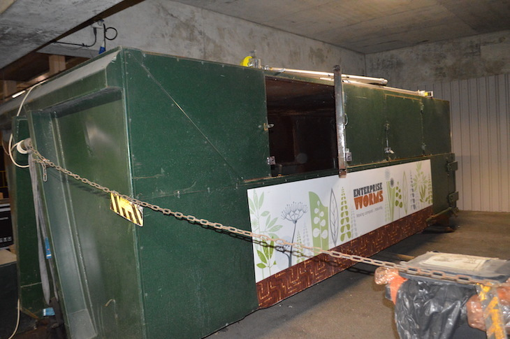 A green skip with a roof, and a hatch